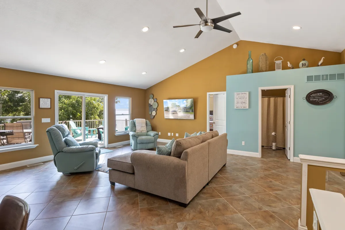 A bright interior lounge with large windows framing expansive outdoor views, comfortable seating, and colorful decor. The abundant natural light and inviting space suggest a perfect spot for relaxation and mindful moments.